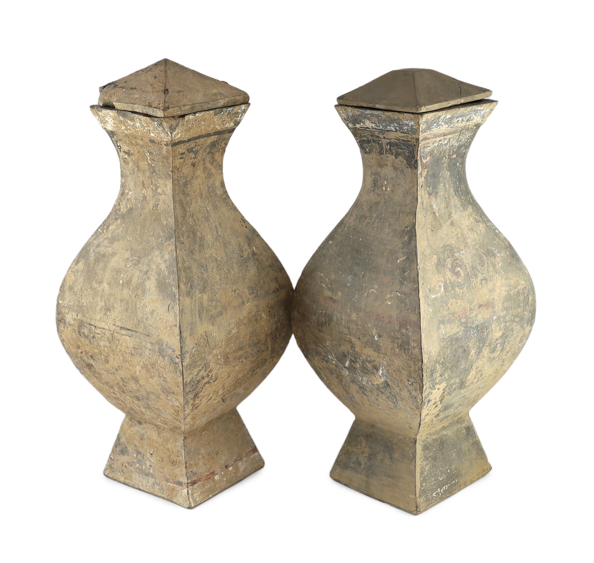 A pair of large Chinese painted terracotta wine jars and covers, fanghu, Han dynasty, 56cm high, one replacement cover and small losses